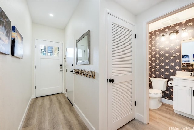 doorway with sink and light hardwood / wood-style floors