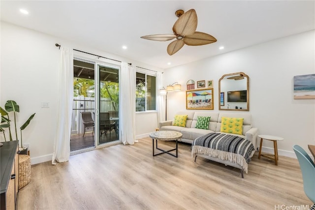 living room with ceiling fan and light hardwood / wood-style flooring