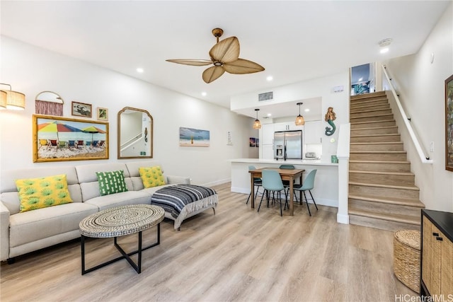 living room with ceiling fan and light wood-type flooring