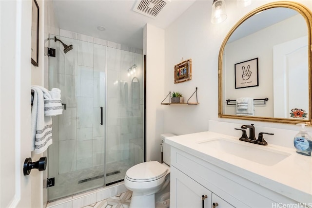 bathroom featuring vanity, a shower with shower door, and toilet