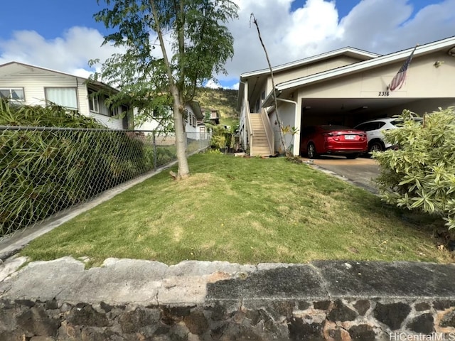 view of side of property featuring a yard and a carport