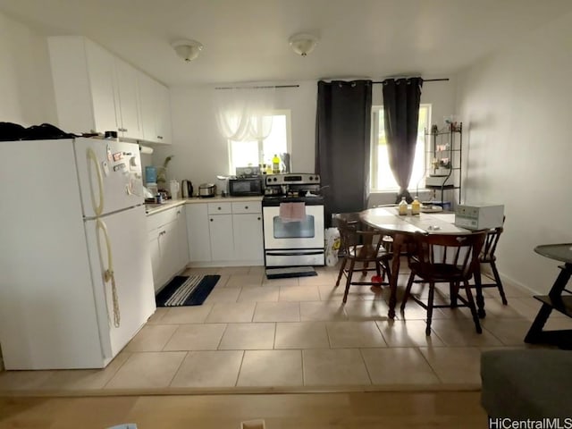 kitchen featuring white cabinets, light tile patterned floors, white fridge, and electric range