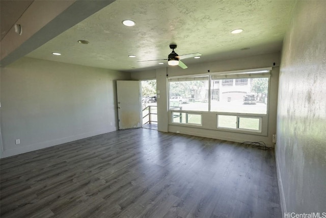 empty room with dark hardwood / wood-style floors, a textured ceiling, and ceiling fan