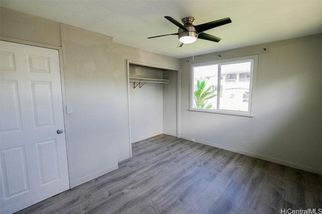 unfurnished bedroom featuring ceiling fan, hardwood / wood-style floors, and a closet