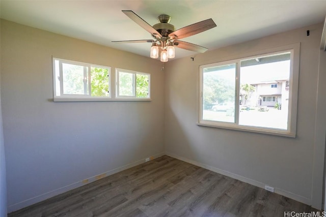 empty room featuring dark wood-type flooring and ceiling fan