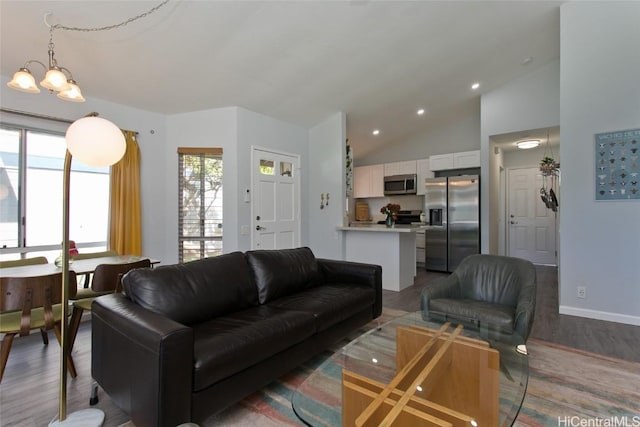 living room with hardwood / wood-style flooring, vaulted ceiling, and a notable chandelier