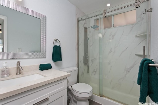 bathroom with vanity, toilet, and a shower with door