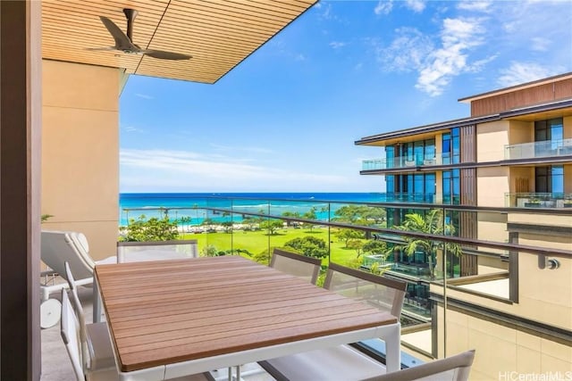 balcony with ceiling fan and a water view