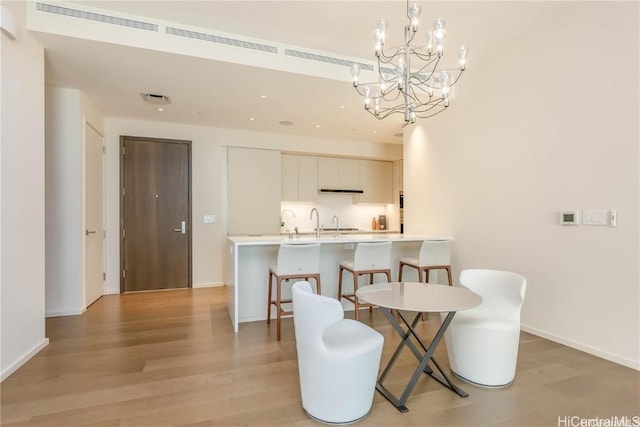 dining space with a chandelier and light hardwood / wood-style flooring