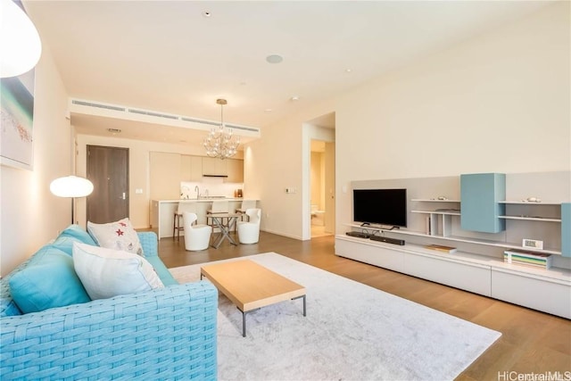 living room featuring an inviting chandelier and wood-type flooring