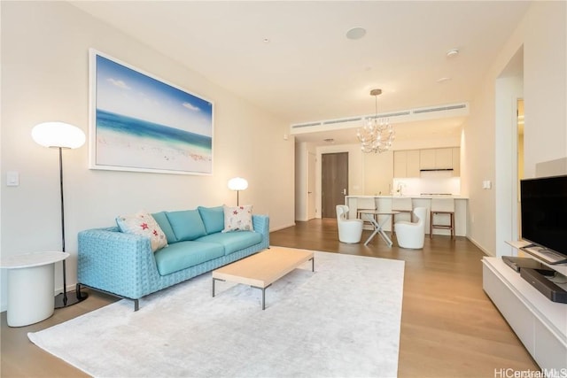 living room featuring a notable chandelier and light hardwood / wood-style floors