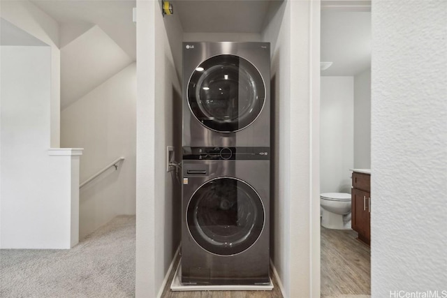 washroom featuring light colored carpet and stacked washer / drying machine