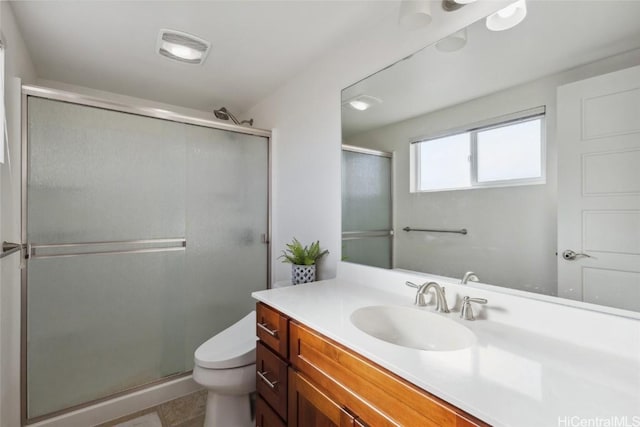 bathroom with vanity, an enclosed shower, and toilet