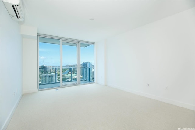 carpeted spare room featuring baseboards, a view of city, a wall of windows, and a wall unit AC