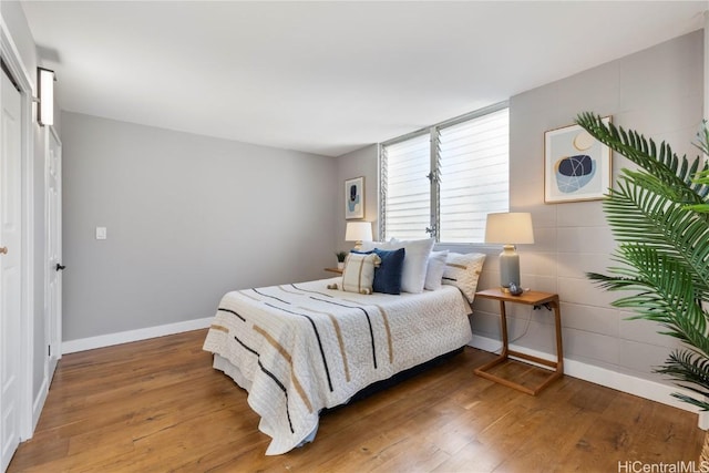 bedroom featuring baseboards and wood-type flooring