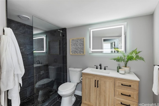 bathroom with vanity, toilet, and tiled shower