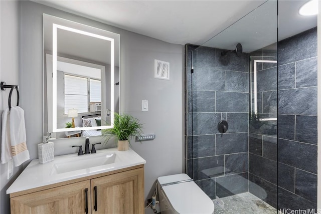 full bath with a tile shower, visible vents, toilet, and vanity