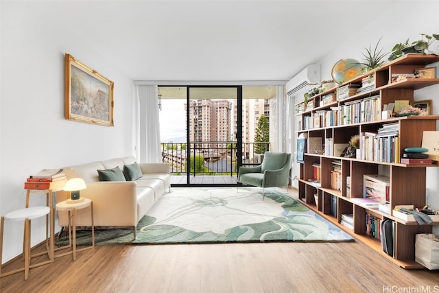 sitting room featuring a wall mounted air conditioner, floor to ceiling windows, and hardwood / wood-style floors