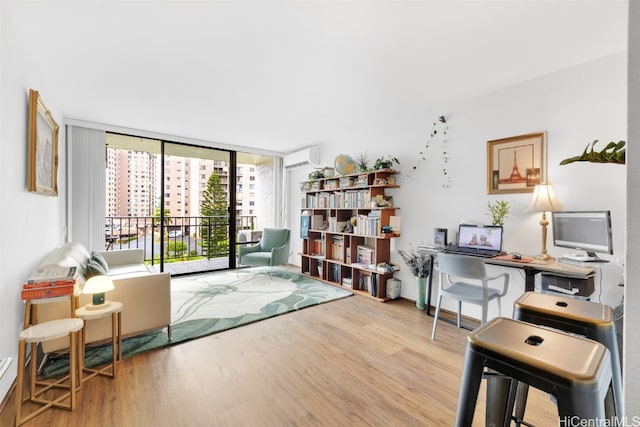 interior space with floor to ceiling windows, hardwood / wood-style floors, and a wall unit AC