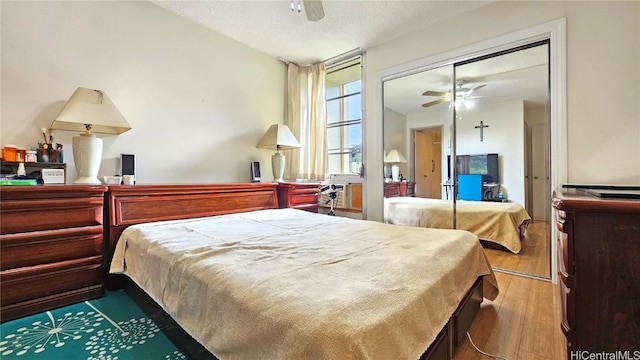 bedroom with a textured ceiling, wood-type flooring, a closet, and ceiling fan