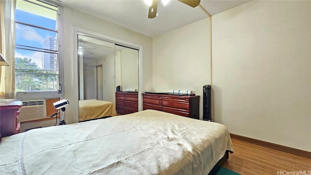 bedroom featuring ceiling fan, hardwood / wood-style floors, a textured ceiling, and a closet