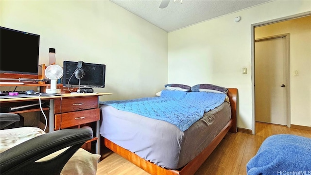 bedroom featuring ceiling fan, lofted ceiling, light hardwood / wood-style flooring, and a textured ceiling