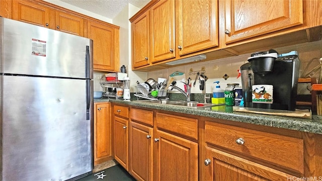 kitchen with sink, stainless steel fridge, and backsplash