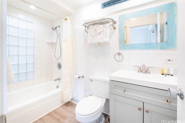 full bathroom featuring wood-type flooring, tile walls, vanity, shower / tub combo, and toilet