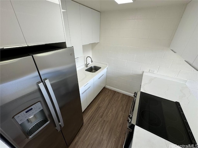 kitchen featuring dark hardwood / wood-style flooring, sink, stainless steel fridge, and white cabinets