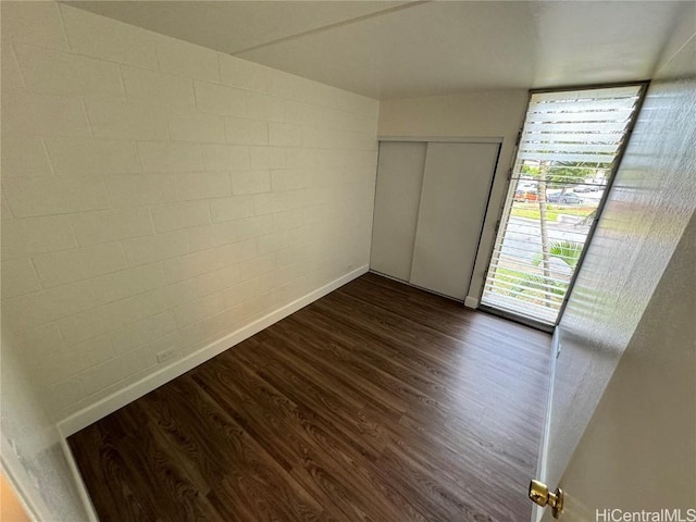 unfurnished bedroom with dark hardwood / wood-style flooring and a closet