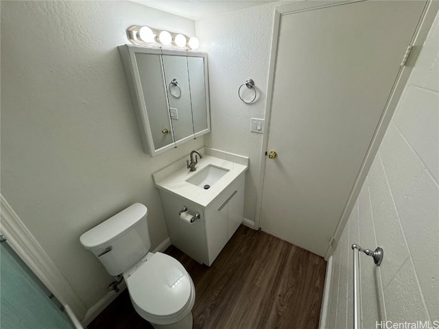 bathroom with vanity, toilet, and hardwood / wood-style floors