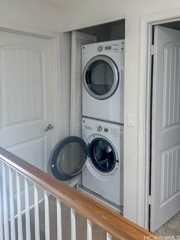 clothes washing area featuring stacked washer and dryer