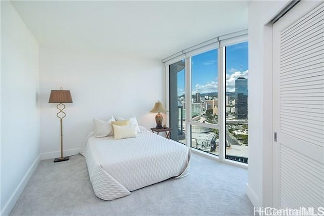 bedroom with floor to ceiling windows, light colored carpet, and access to exterior