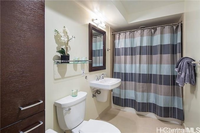 bathroom featuring toilet and curtained shower