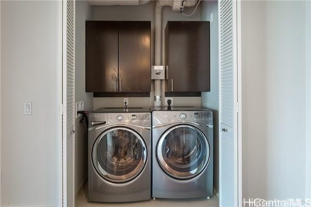 washroom with cabinets and washer and clothes dryer