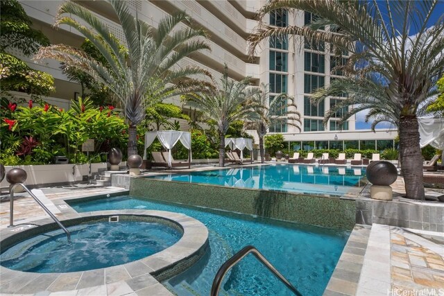 view of swimming pool featuring a hot tub