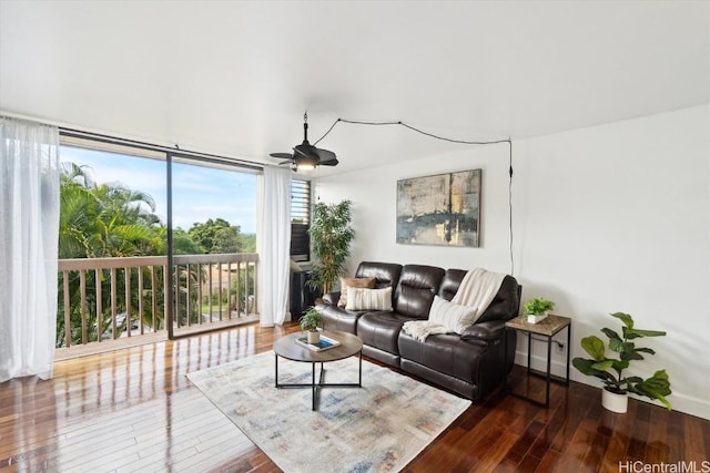 living room featuring dark hardwood / wood-style flooring, expansive windows, and ceiling fan