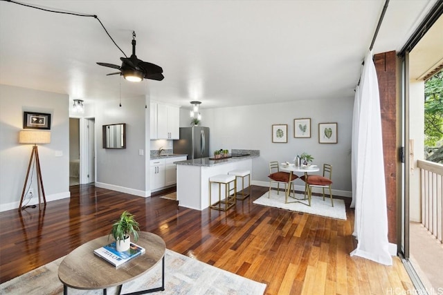 living room with dark hardwood / wood-style floors, sink, and ceiling fan