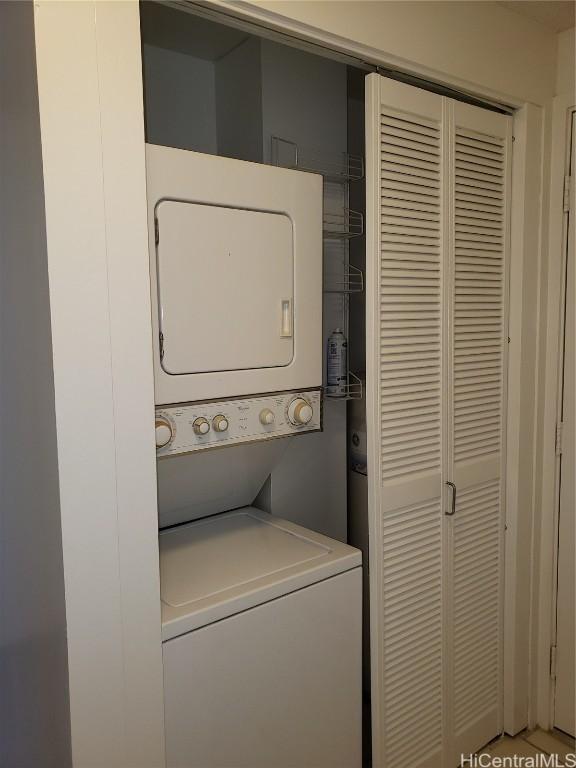 clothes washing area with stacked washer / dryer