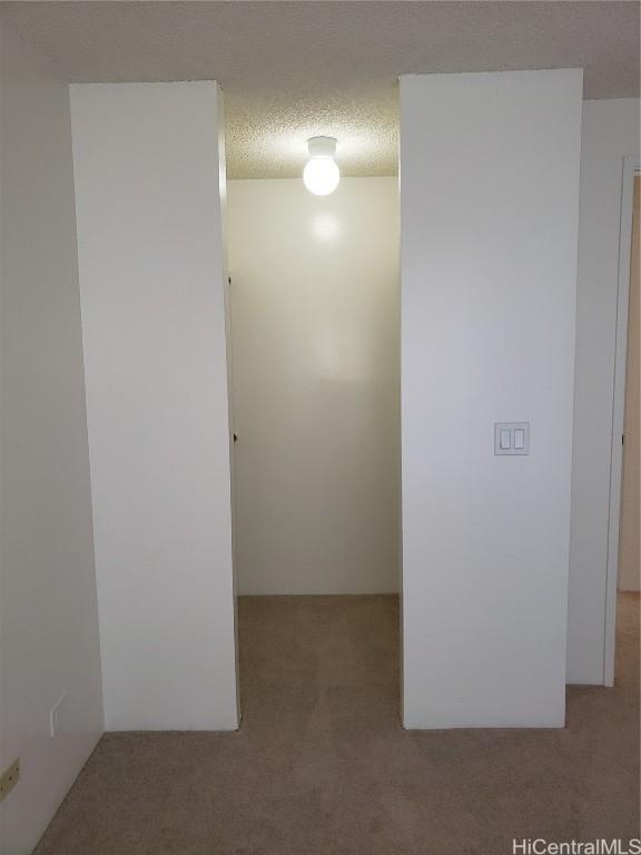 unfurnished room with light carpet and a textured ceiling