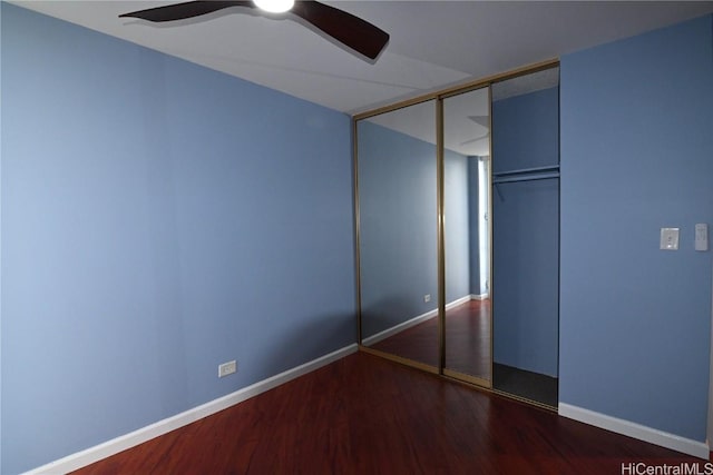 unfurnished bedroom featuring ceiling fan, dark hardwood / wood-style flooring, and a closet