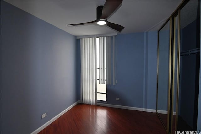 empty room with ceiling fan and dark hardwood / wood-style flooring