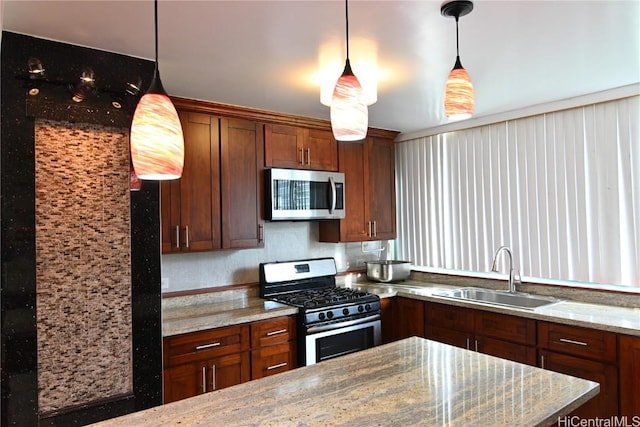 kitchen featuring sink, decorative light fixtures, stainless steel appliances, and light stone countertops