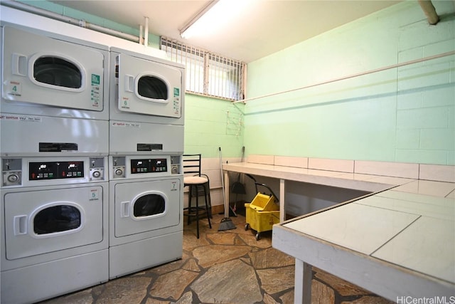 clothes washing area with washer and clothes dryer and stacked washer and clothes dryer