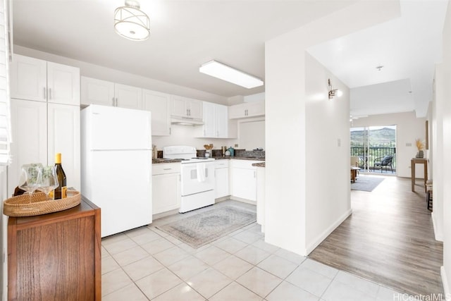 kitchen featuring white cabinetry, light tile patterned floors, and white appliances