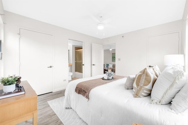 bedroom with ceiling fan, connected bathroom, and light hardwood / wood-style flooring