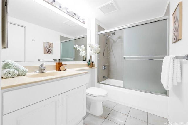 full bathroom with toilet, vanity, bath / shower combo with glass door, and tile patterned flooring