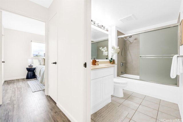 full bathroom with vanity, combined bath / shower with glass door, wood-type flooring, and toilet