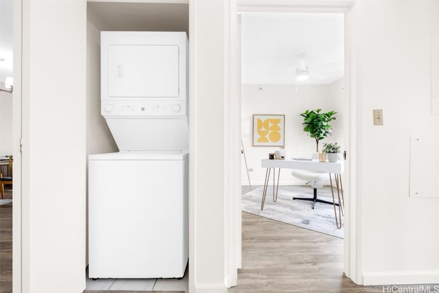 washroom with light wood-type flooring, ceiling fan, and stacked washing maching and dryer