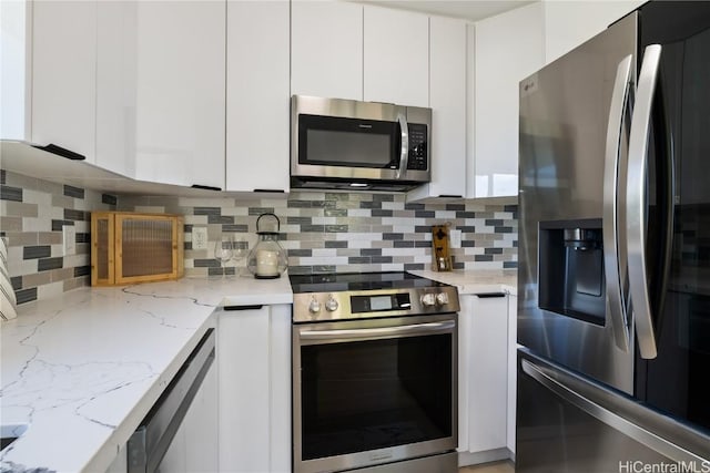 kitchen featuring white cabinetry, appliances with stainless steel finishes, light stone counters, and decorative backsplash